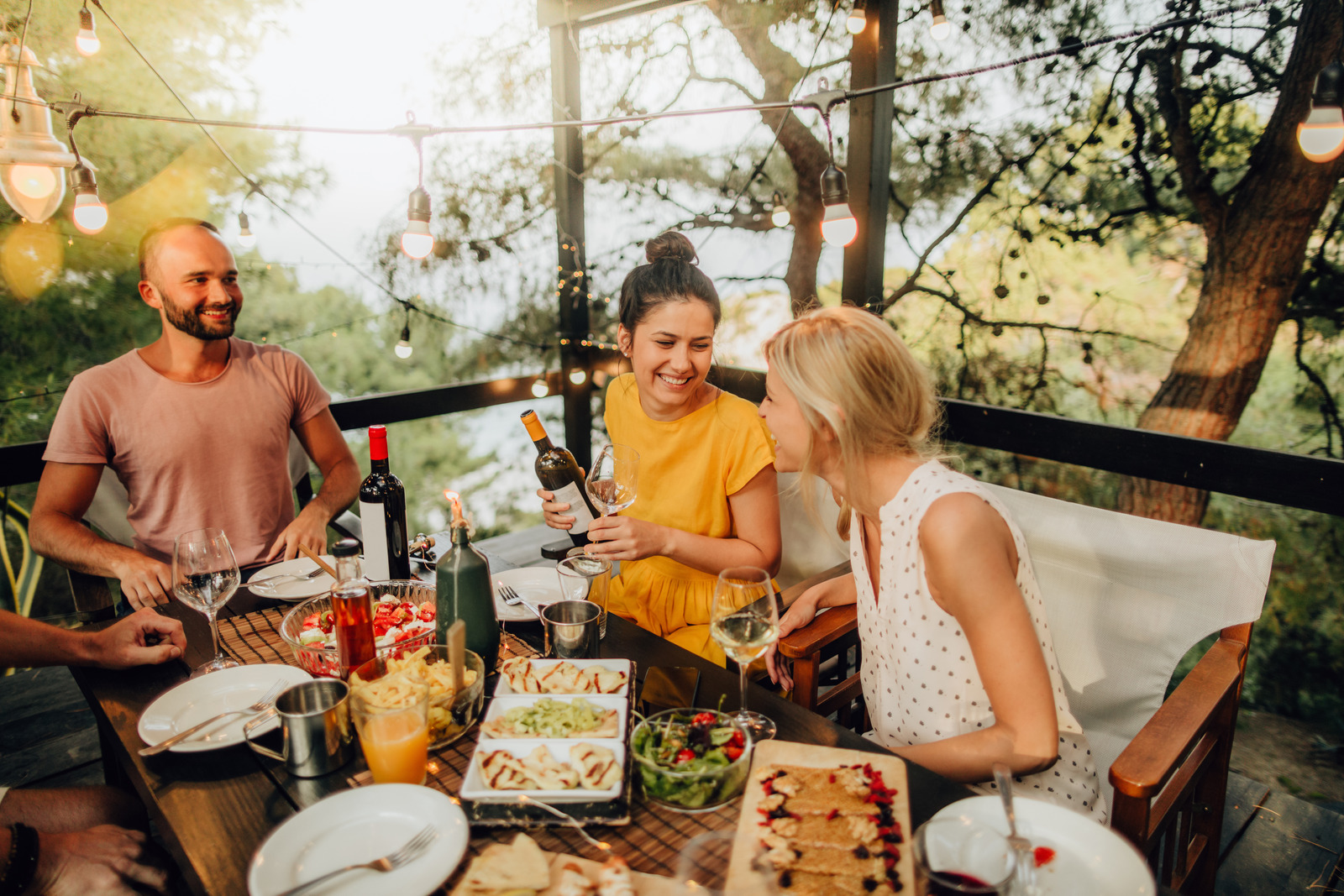 des amis prennent l'apéro sous une pergola Vertu